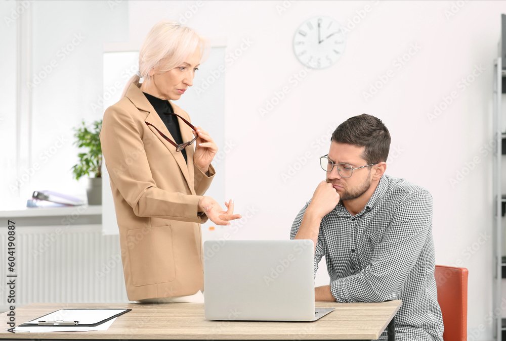 Manager scolding an employee at a laptop
